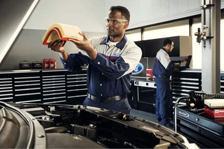 ford technician examines air filter
