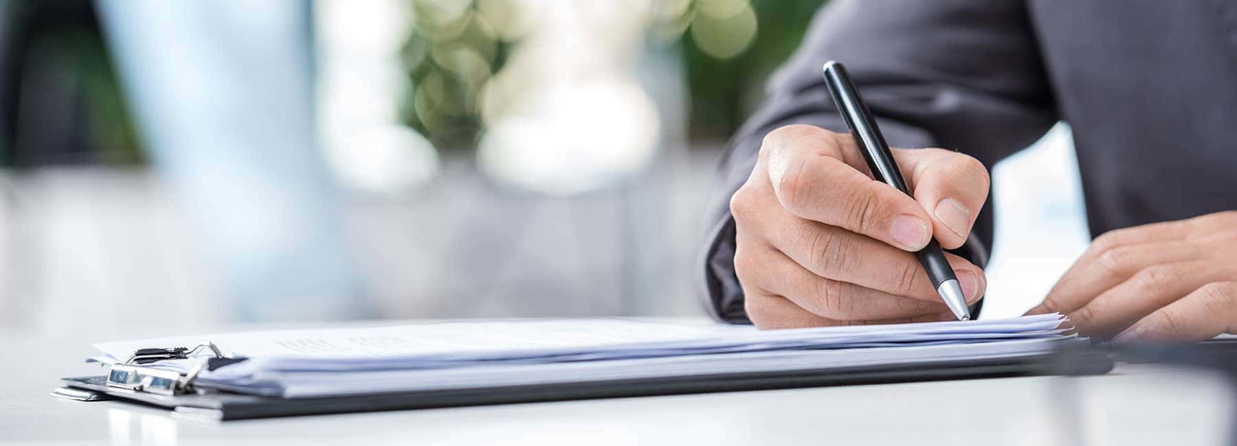 man signs papers in well lit room