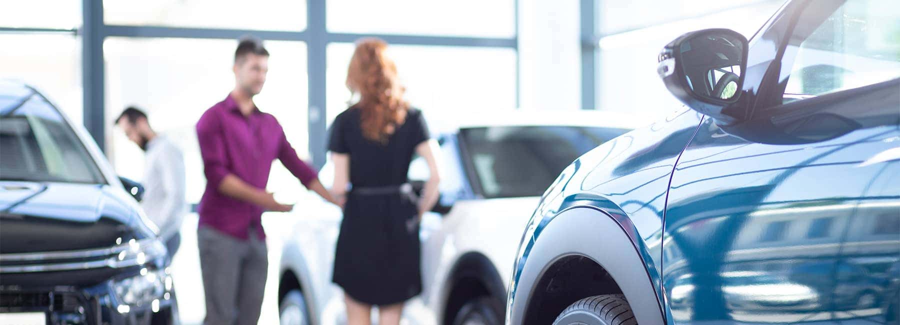 Customers reviewing cars in a showroom