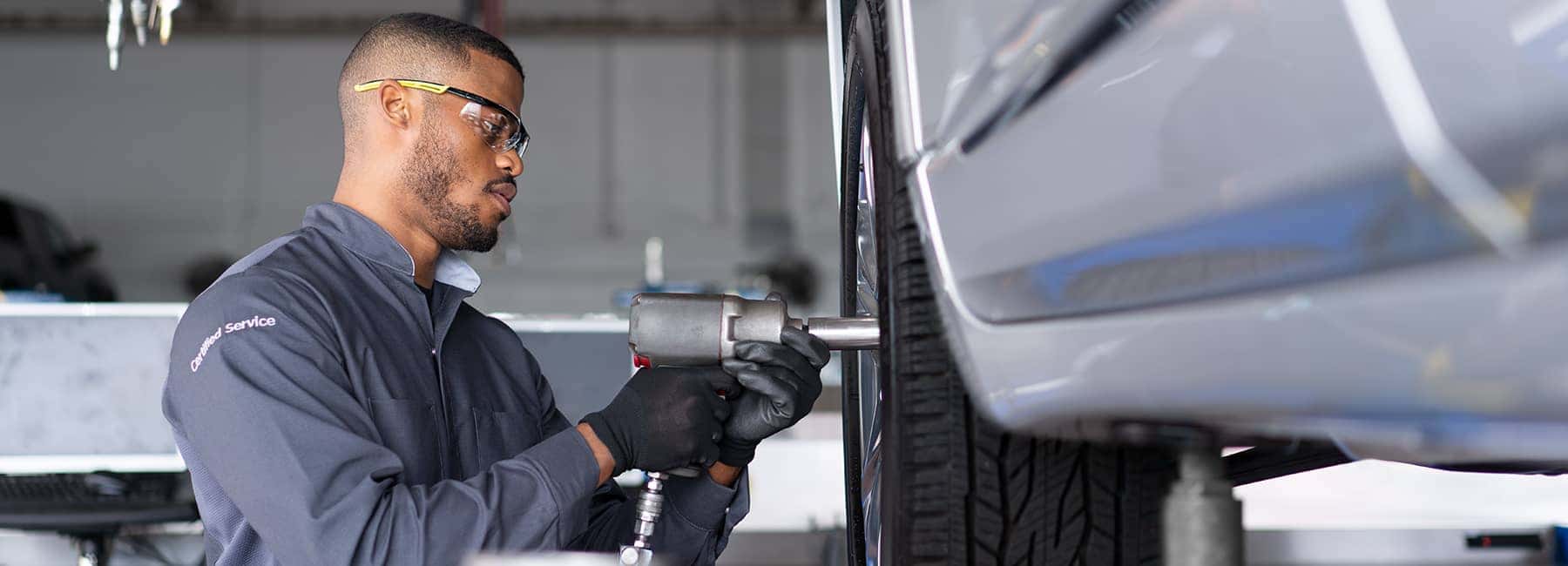 Certified technician tightens bolts on tire