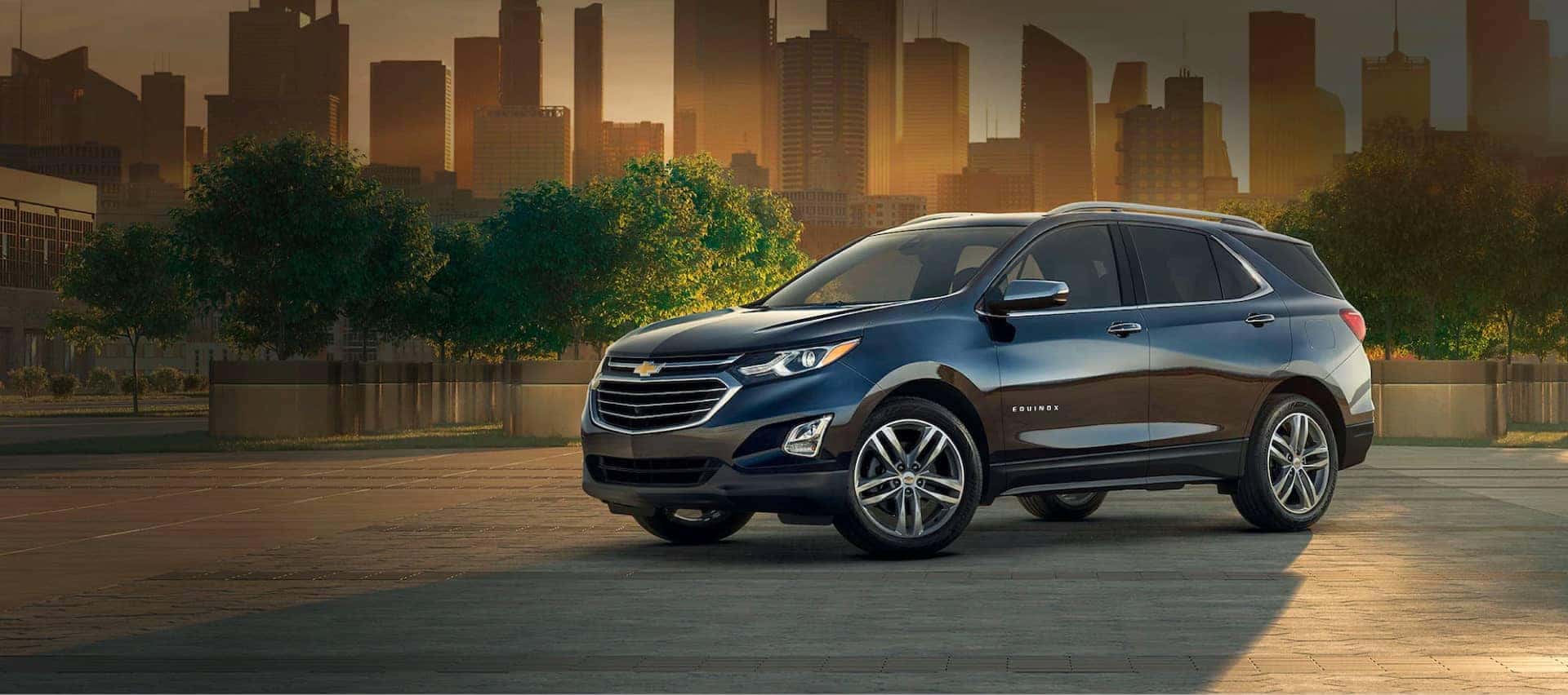 Chevrolet Equinox parked in a city plaza at sunset.