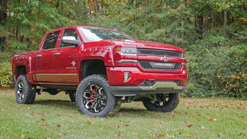 jacked up red chevy trucks