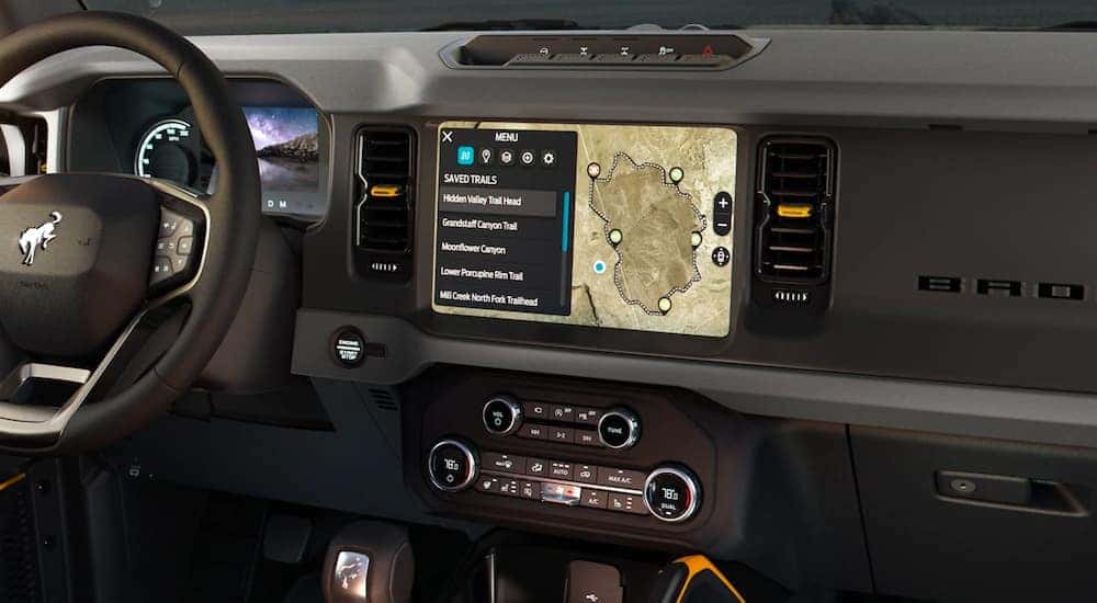 The black interior is shown with a close up of the infotainment screen on a 2021 Ford Bronco.
