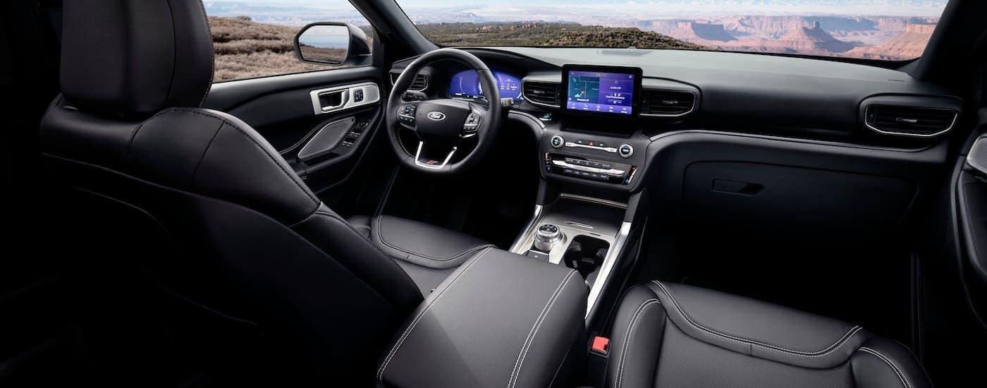 The black interior, dashboard, and infotainment screen are shown in a 2021 Ford Explorer.