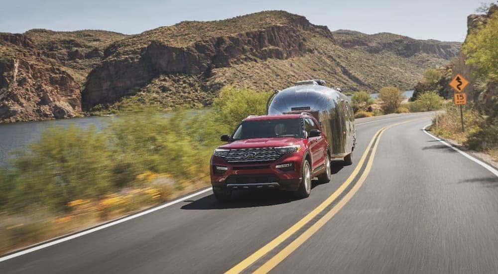A red 2021 Ford Explorer is towing an Airstream trailer.