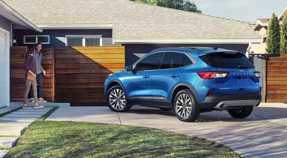 A blue 2021 Ford Escape is parked in a modern driveway.