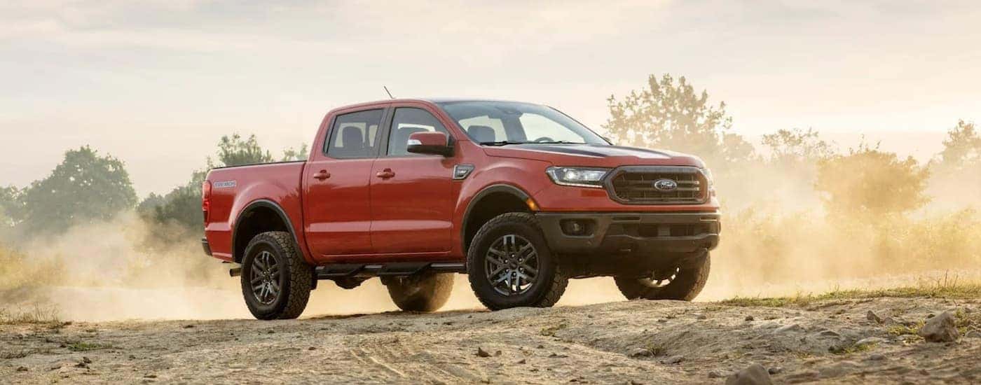 A red 2021 Ford Ranger Tremor Lariat is parked on a dirt trail.
