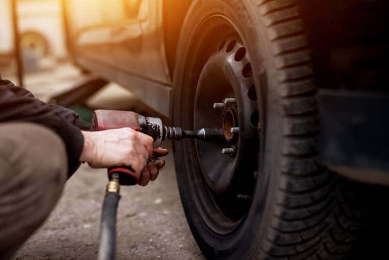 service-specialist-putting-on-tire-mobile