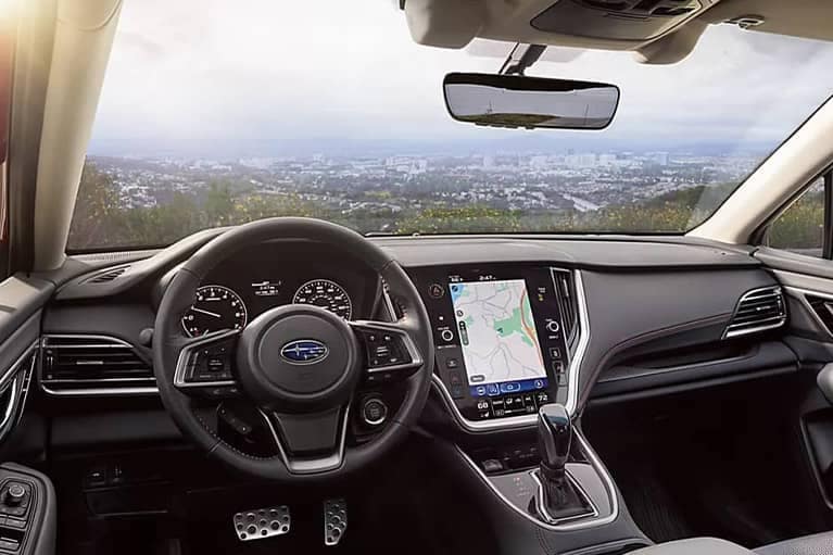 2022 Subaru Legacy-interior veiw from back of drivers side at angle-cityscape background-black_grey