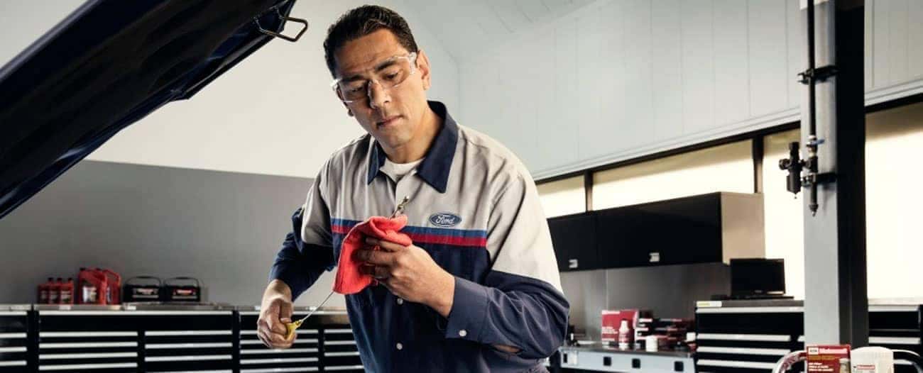 Ford-Service technician checks oil level