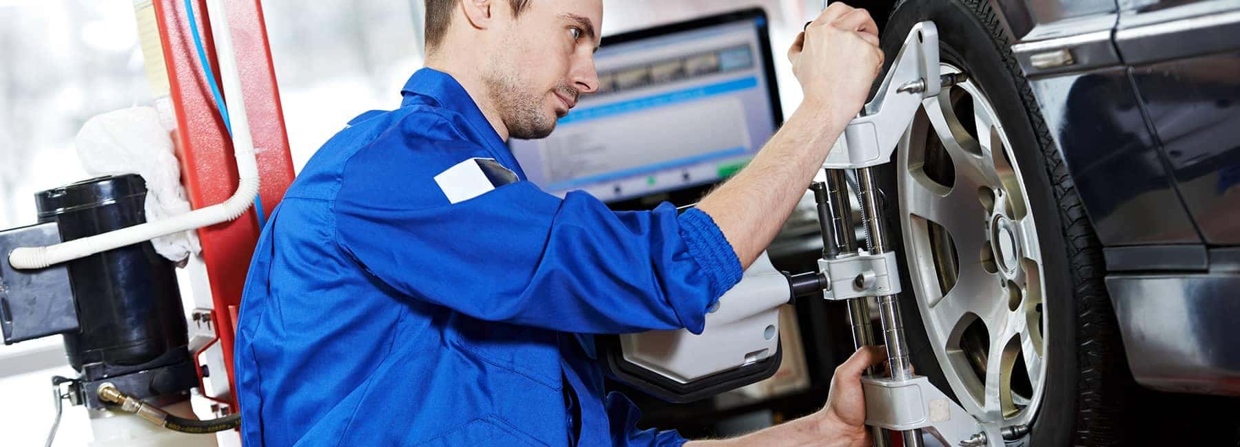 technician installs and aligns new car tire