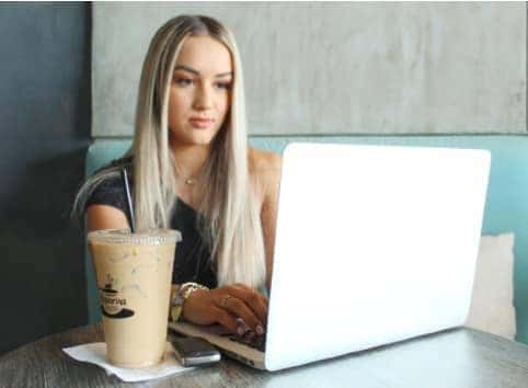 Person using laptop with a coffee