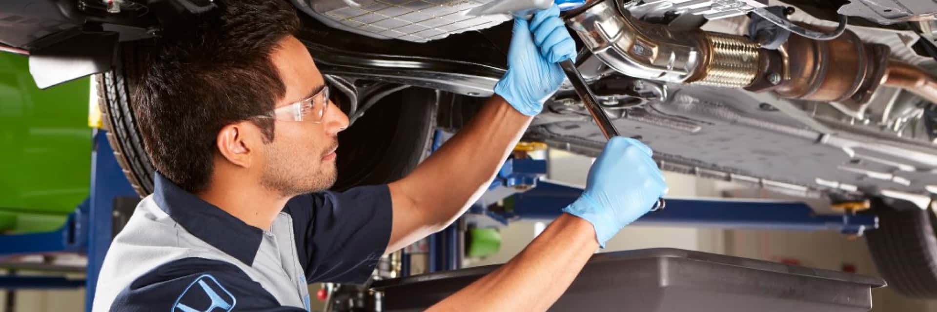 Honda-Technician-doing-an-oil-change-underneath-a-vehicle
