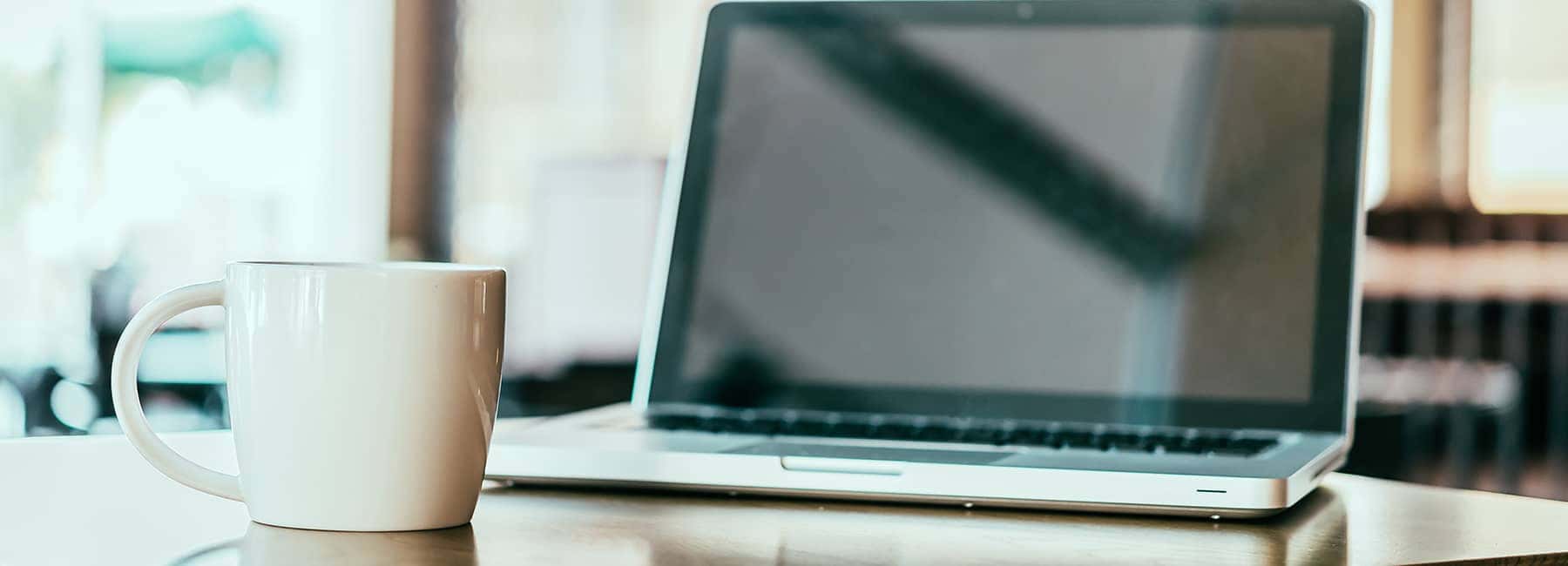 someones-laptop-by-a-coffee-mug