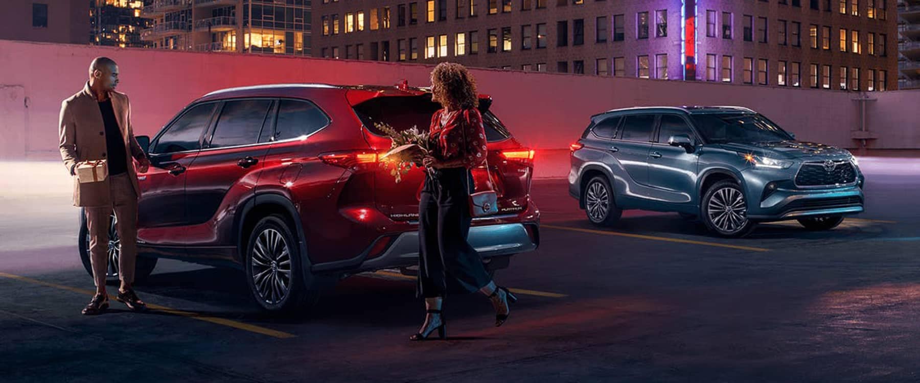 2021 Toyota Highlander Hybrid parked with two people with gifts