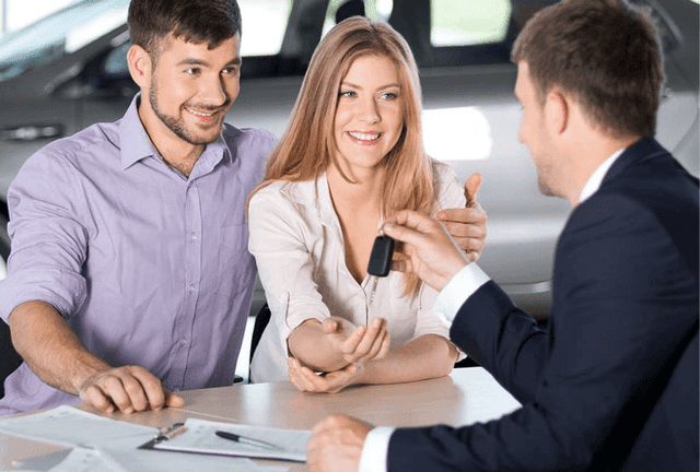 dealer-hands-new-car-keys-to-smiling-couple