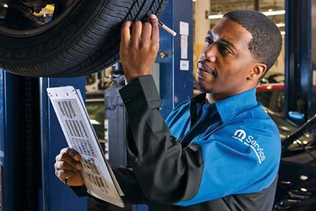 mopar-service-technician-checks-tire