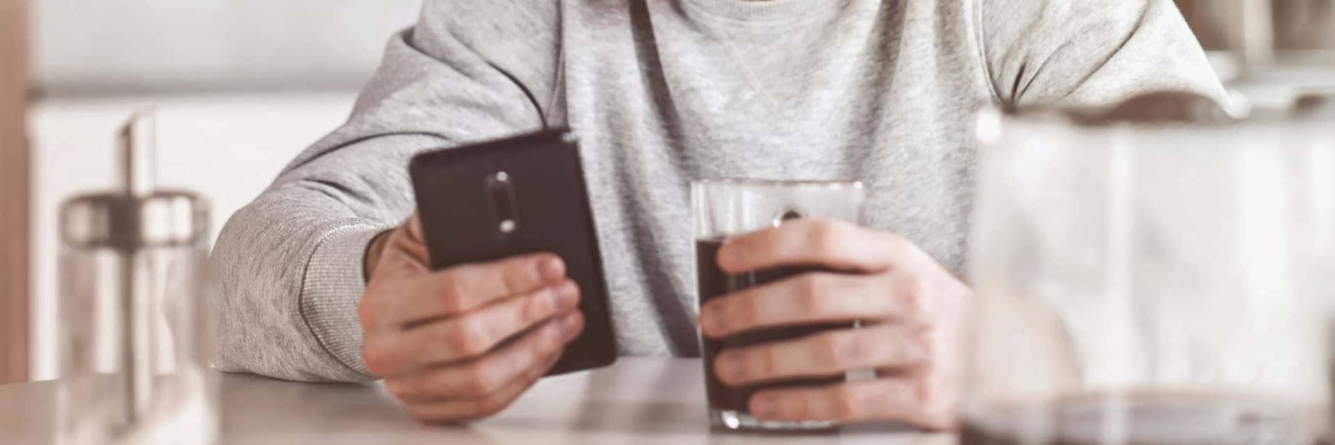 person-on-cell-phone-with-drink-mobile