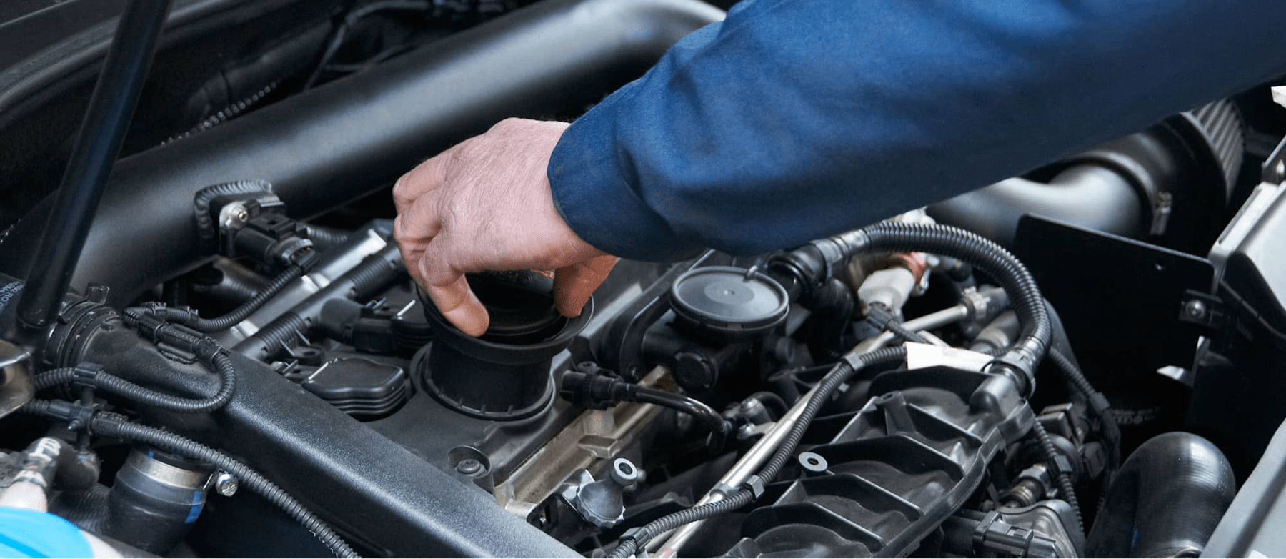 service technician unscrews oil reservoir in car engine
