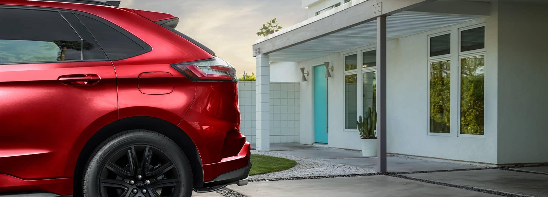 Red 2021 Ford Edge parked in front of a modern home