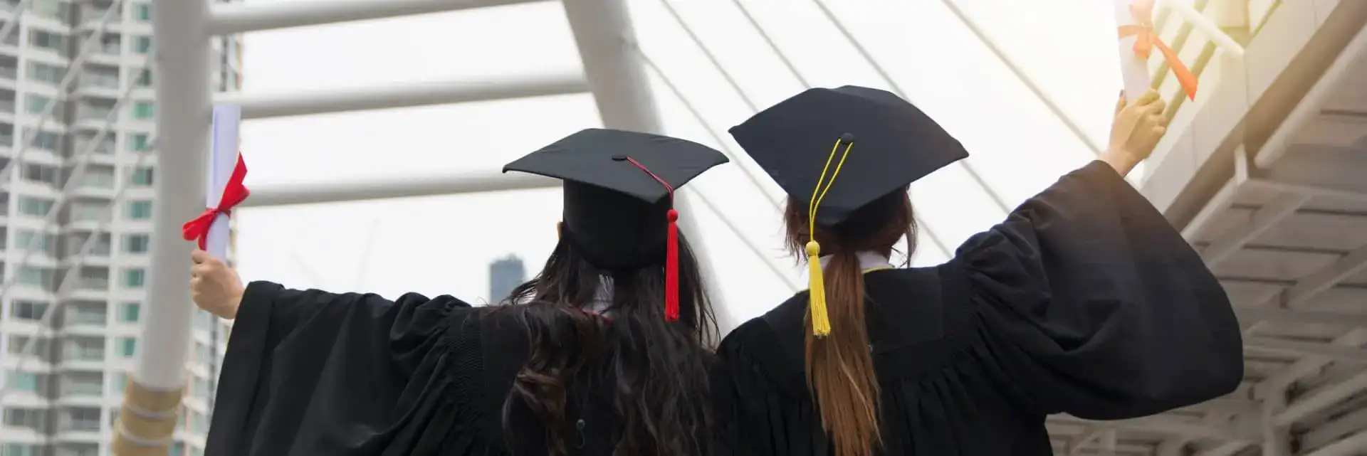two college grads celebrating