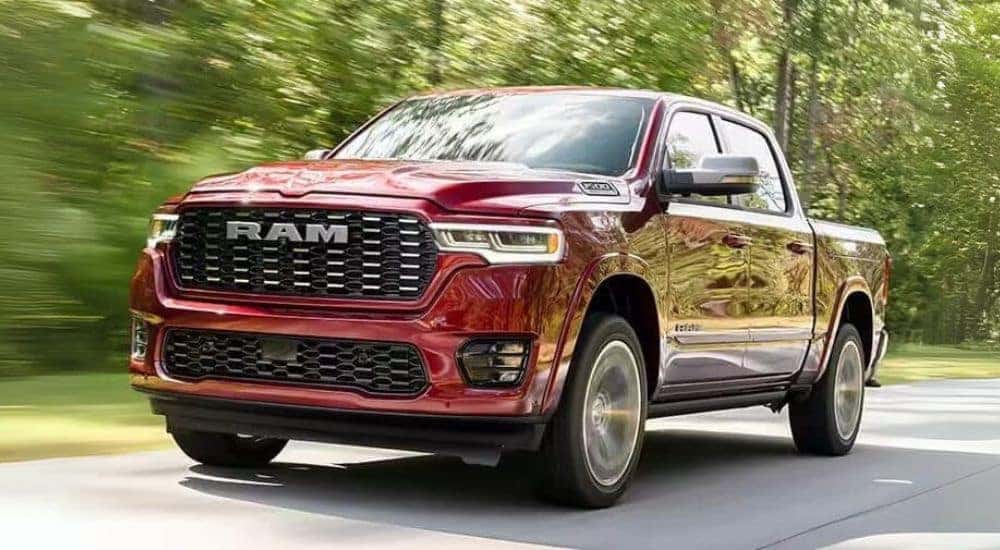 A red 2025 Ram 1500 is shown driving on an open road.