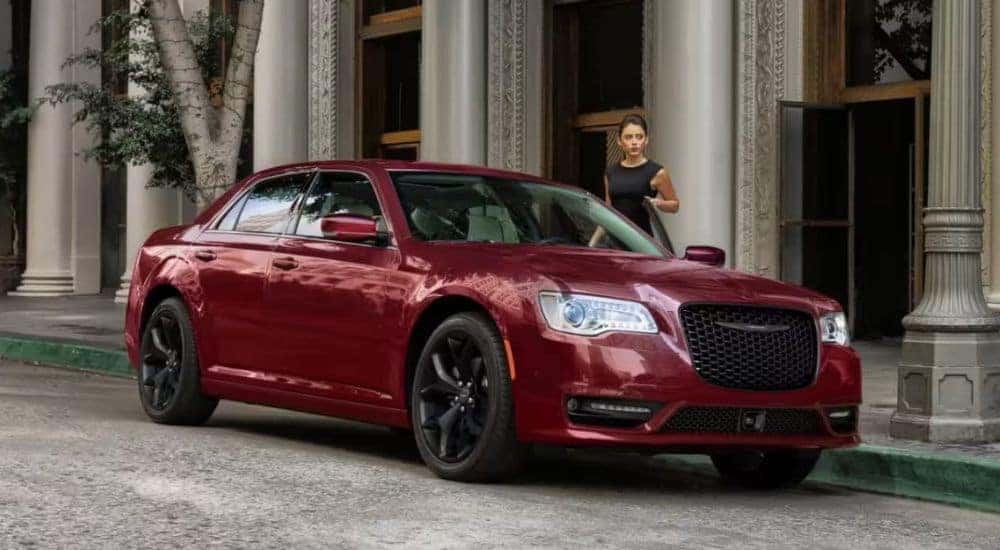 A red 2023 Chrysler 300 Touring L is shown on a city street.