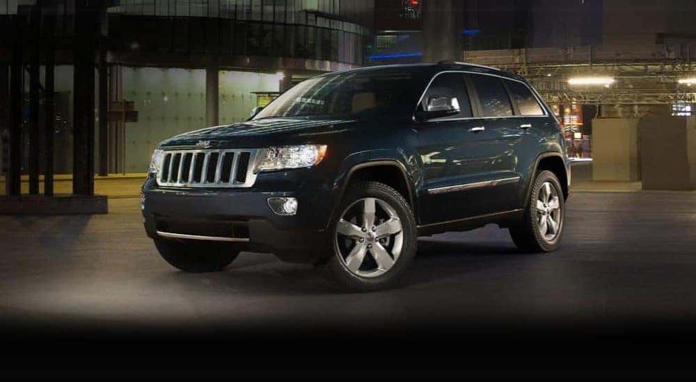 A dark blue 2011 Jeep Grand Cherokee is shown at night.