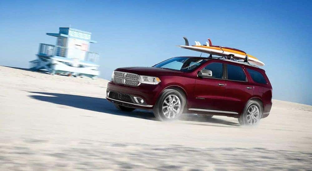 A maroon 2020 Dodge Durango is shown driving on the beach after leaving a used Dodge dealership.