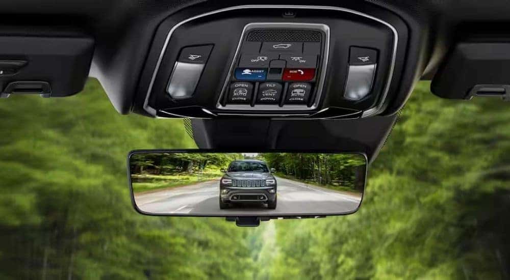 A grey 2024 Jeep Grand Cherokee is shown on a rear view mirror.