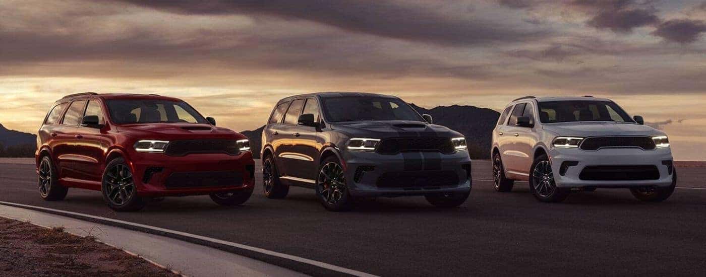 A red, a grey, and a white 2024 Dodge Durango are shown.