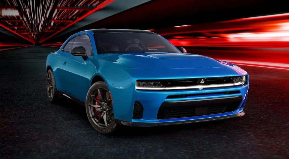 A blue 2025 Dodge Charger SIXPACK is shown parked near a Dodge dealer near Charlotte.