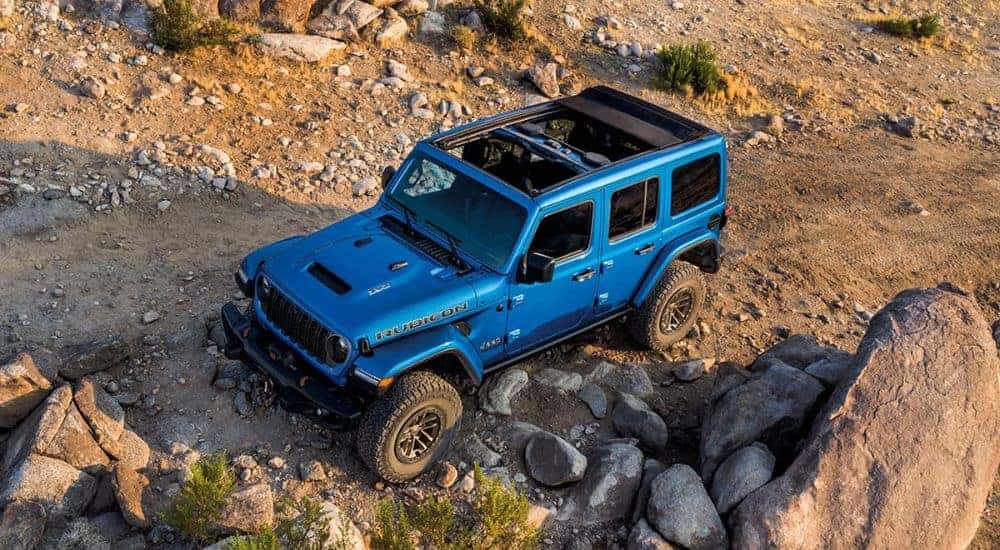 A blue 2024 Jeep Wrangler Rubicon 392 is shown off-road.