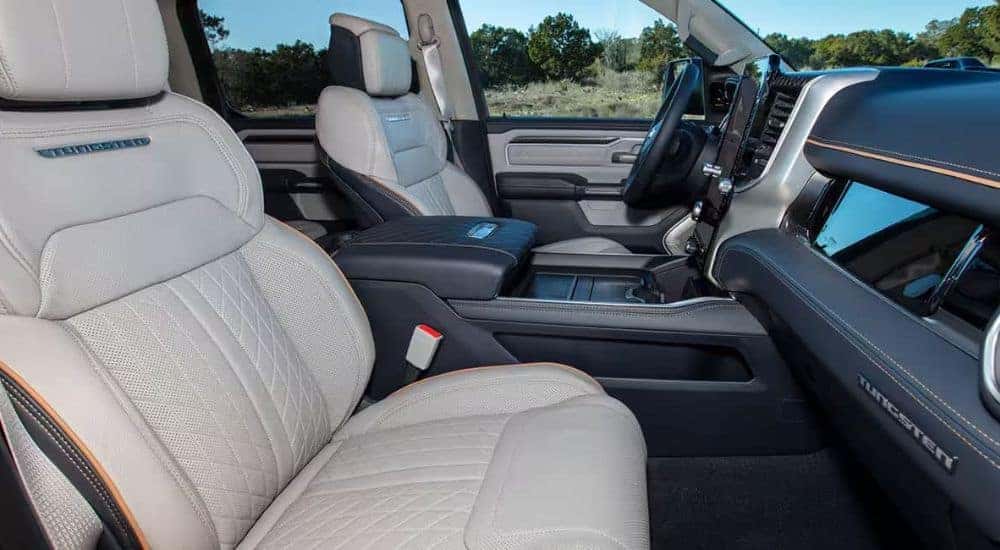 A close-up shows the grey and black interior in a 2025 Ram 1500 Tungsten.