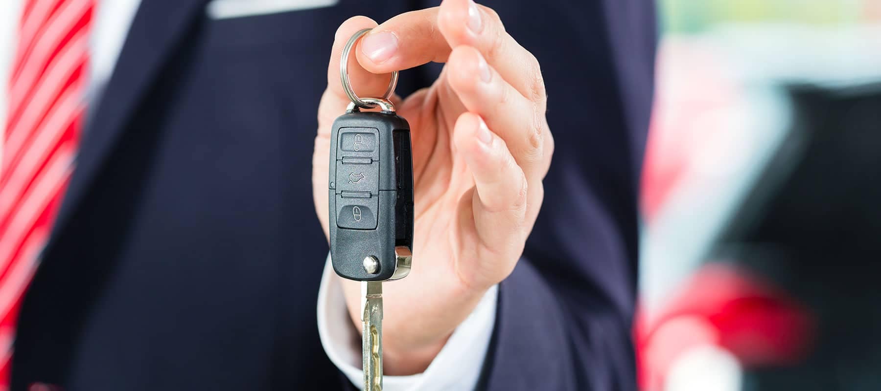 man in suit holding a car key