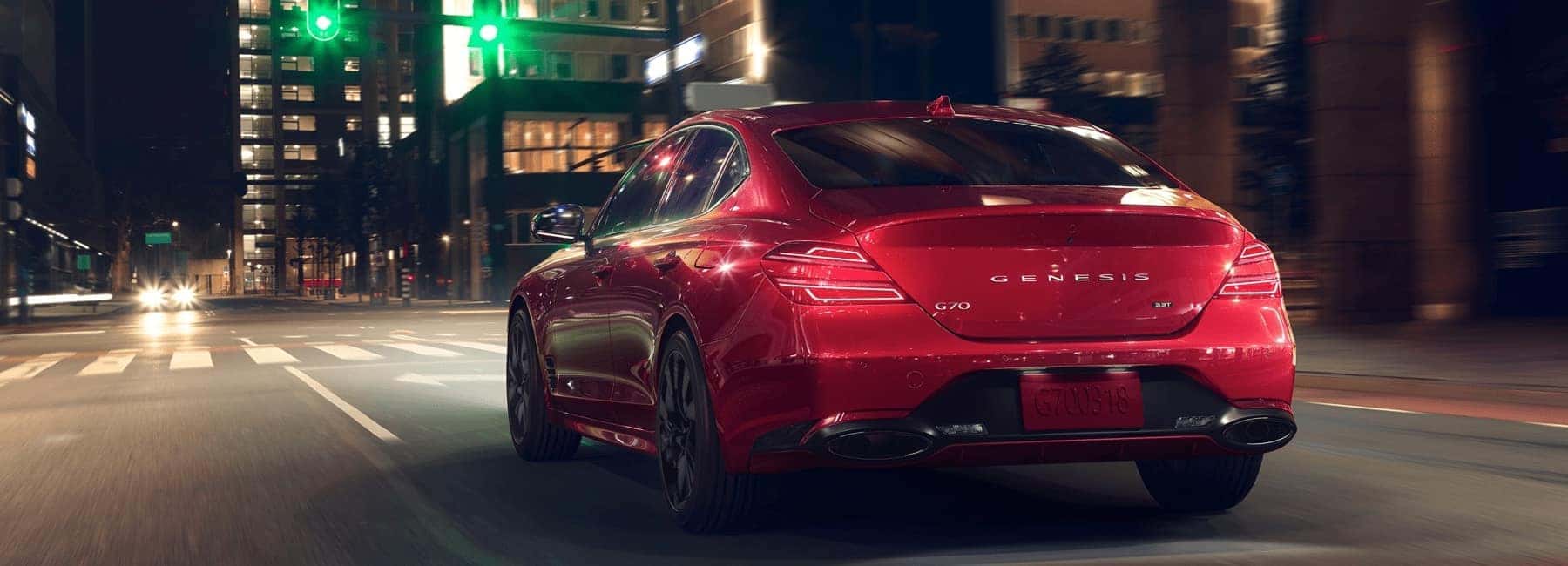 red-G70-drives-city-street-nighttime