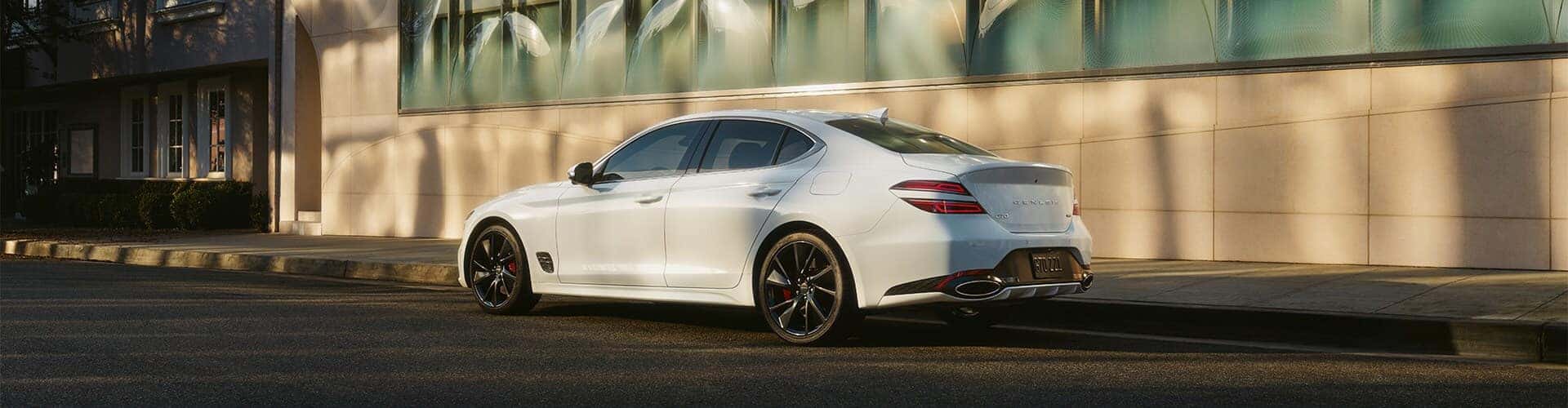 Genesis Dealership near Westfield, MA | White 2023 Genesis G70 Parked Next to Building with Large windows