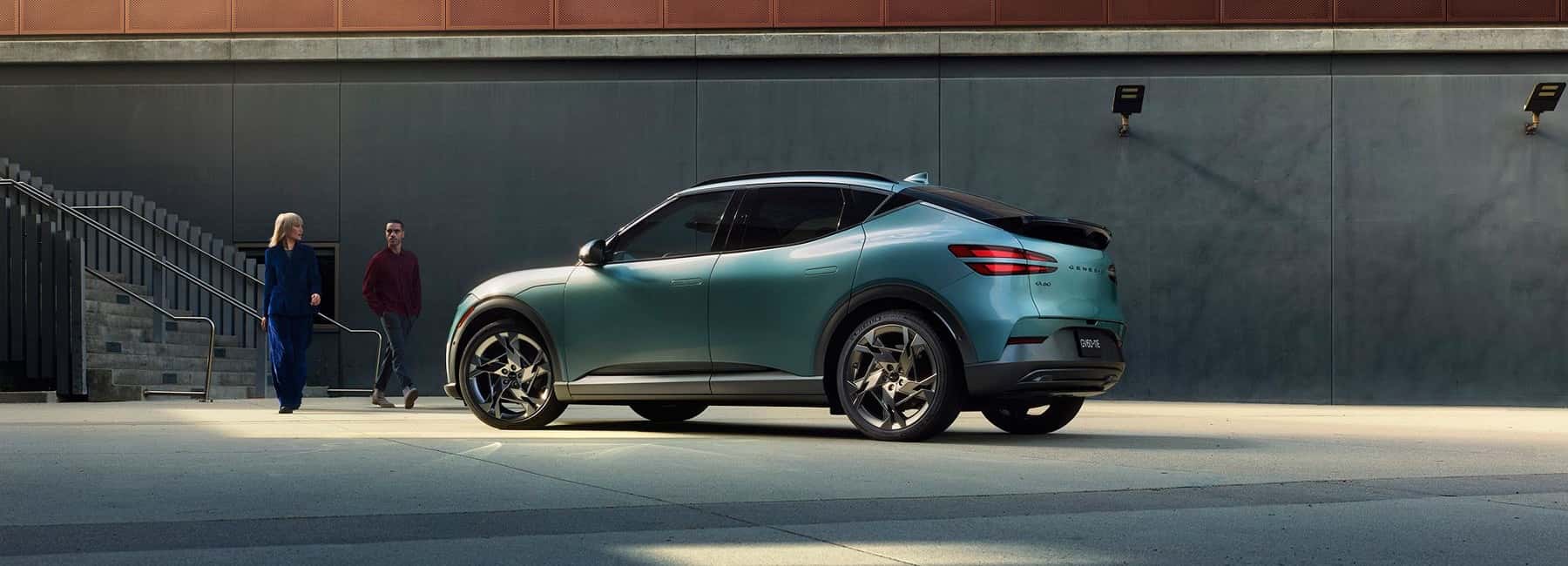 couple walks toward Genesis GV60