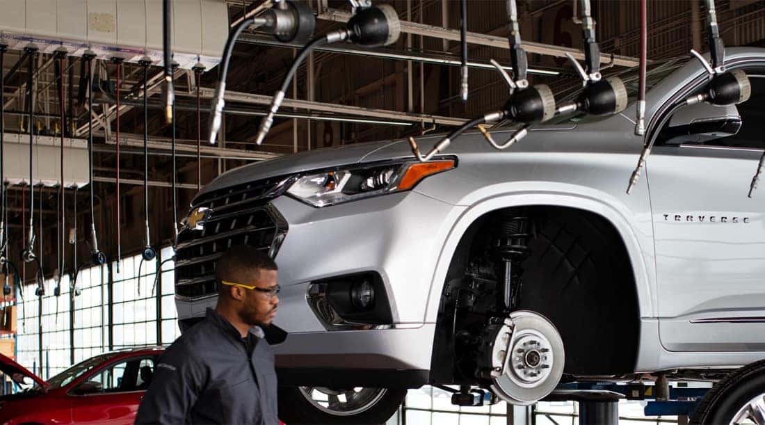 A mechanic working on a lifted car