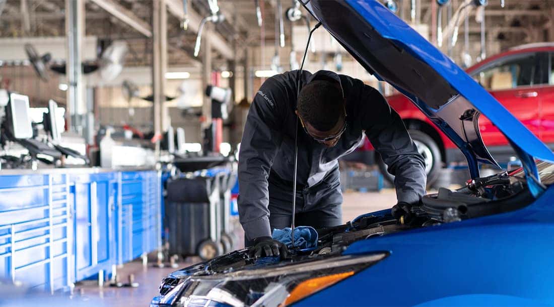 A mechanic working under the hood of a car