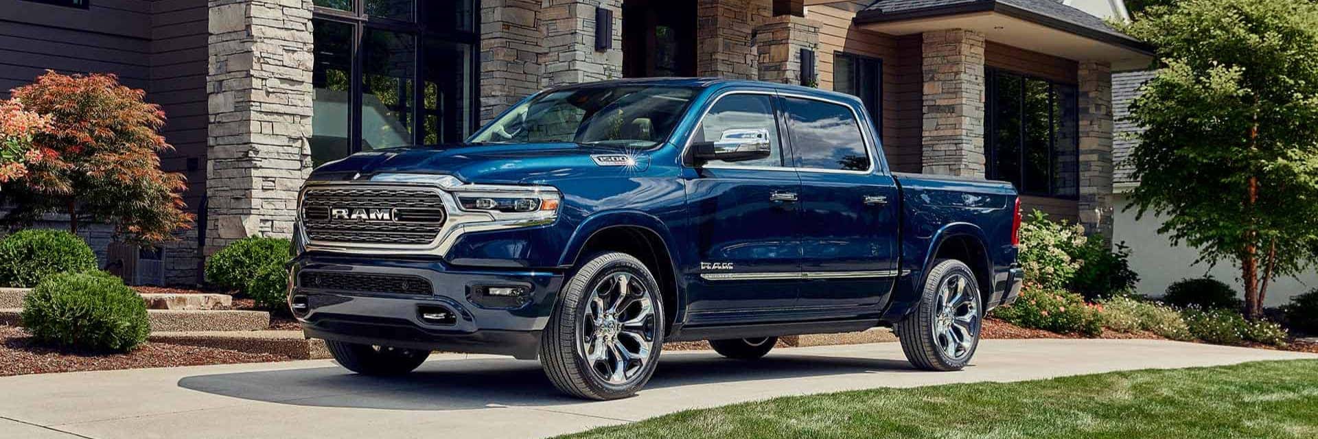 2024 Ram 1500 parked in front of large modern home in the curved driveway