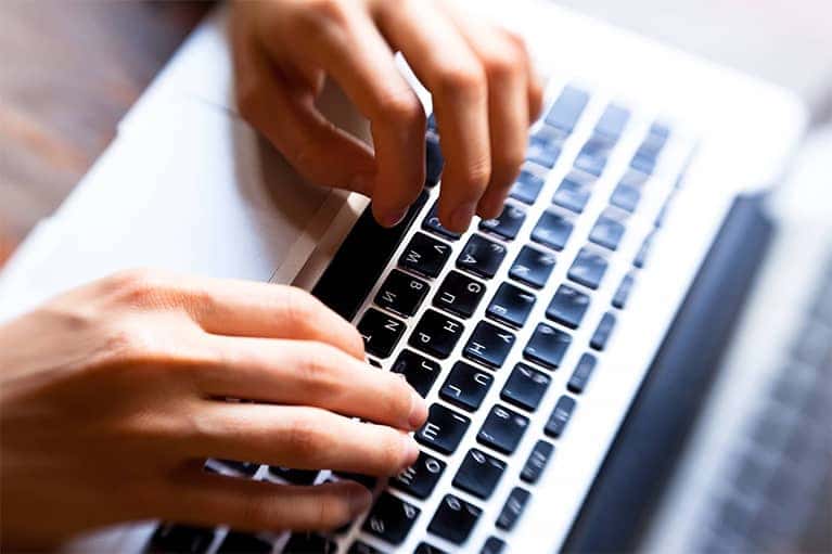 Hands Typing on Laptop Keyboard