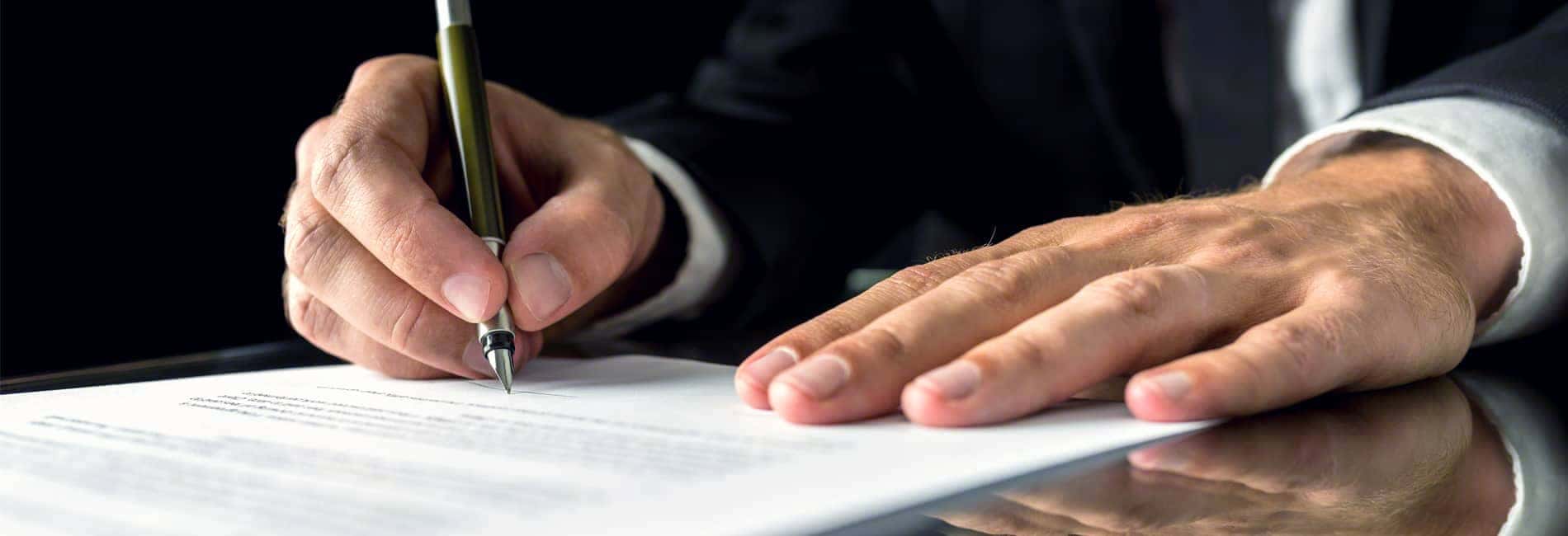 Hands of Man in Suit Signing Document