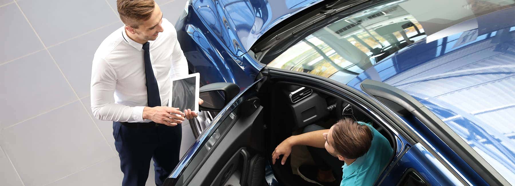 Car salesman reviews car details with a male customer