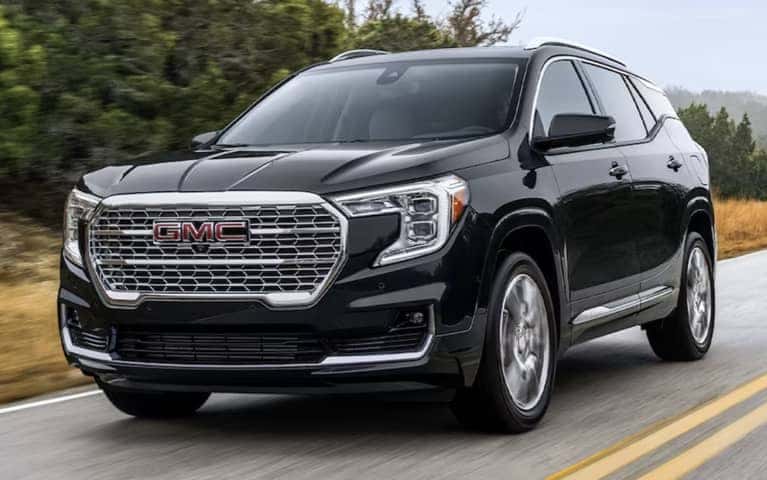 2024 GMC Denali driving down a road