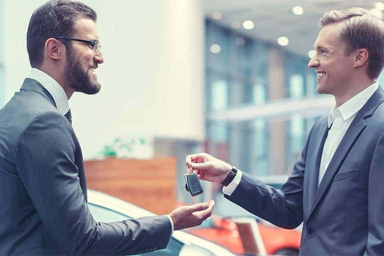 Dealership Salesman Handing car Keys Over to Man