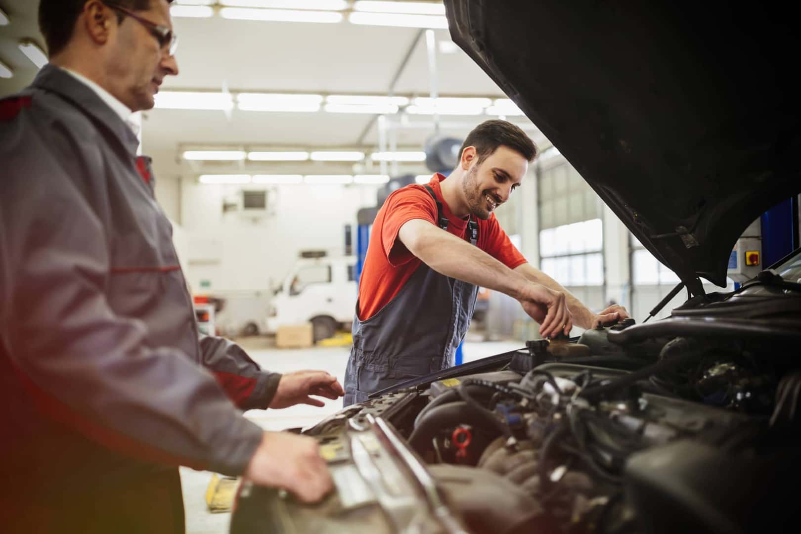 Mechanic Screwing Cap on in Car Engine 