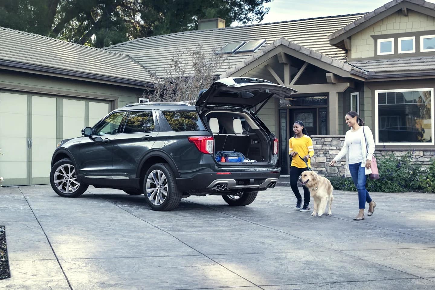 2022 Ford Explorer in driveway with girl, dog, and adult women 