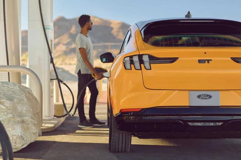man with 2022-MUSTANG-MACH-E at electric charging station