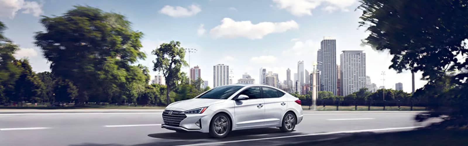 White-Hyundai-sedan-driving-outside-the-city